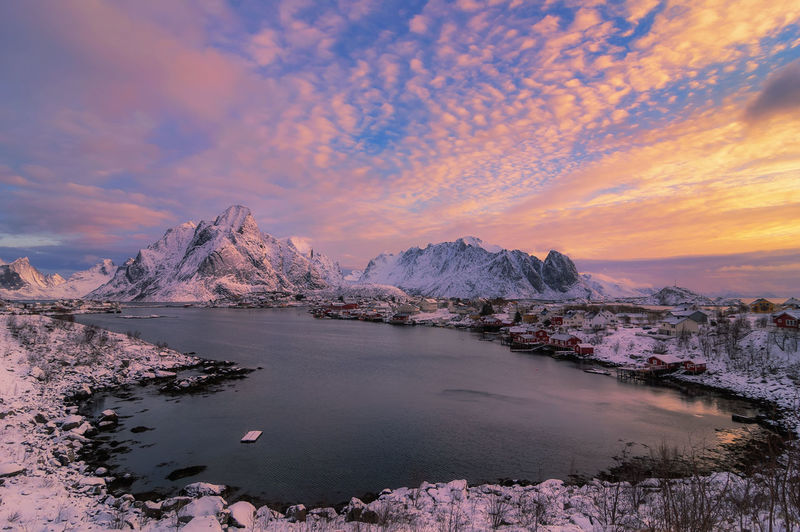 Scenic view of lake by mountains against sky during sunset norway