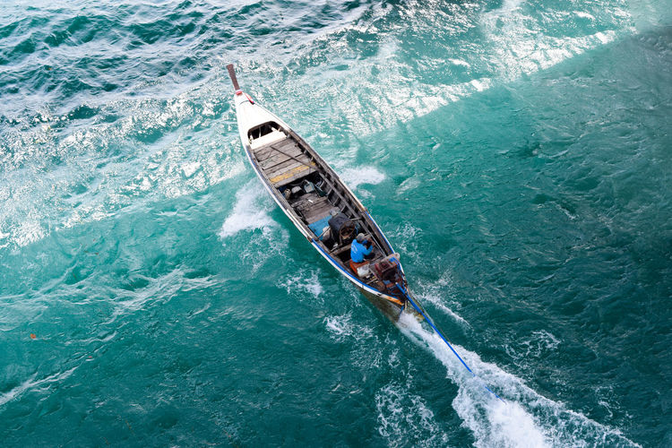 High angle view of man sitting in motor boat on sea