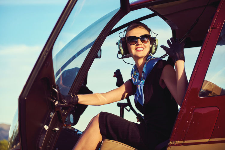 Female pilot sitting in helicopter