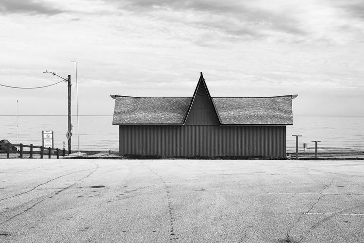 A shuttered commercial building taken from a empty parking lot against a cloudy sky wasaga beach 