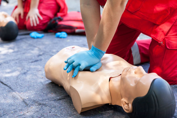 Midsection of man with cpr dummy during training