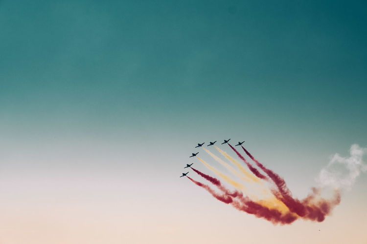 Low angle view of airshow against clear blue sky