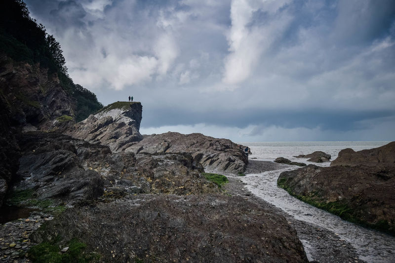 Rock formations on shore against sky