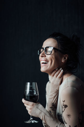 Smiling young woman drinking glass