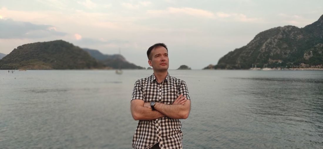 Portrait of man standing in sea against sky