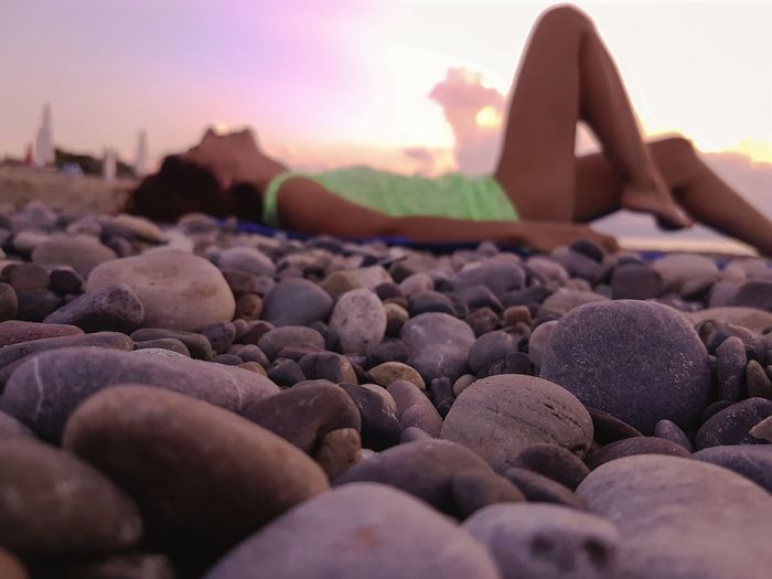 Woman lying at beach during sunset