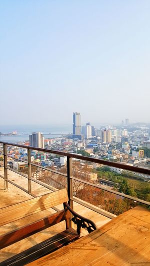 Scenic view of sea and buildings against clear sky