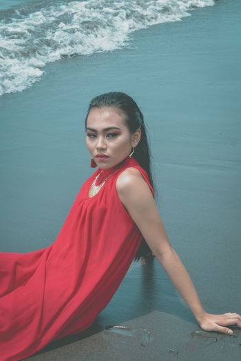 Beautiful woman sitting on shore at beach