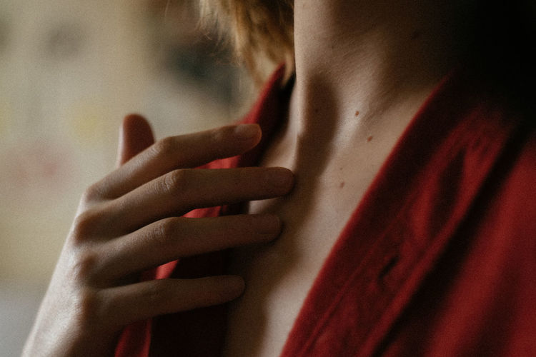 Midsection of woman touching neck
