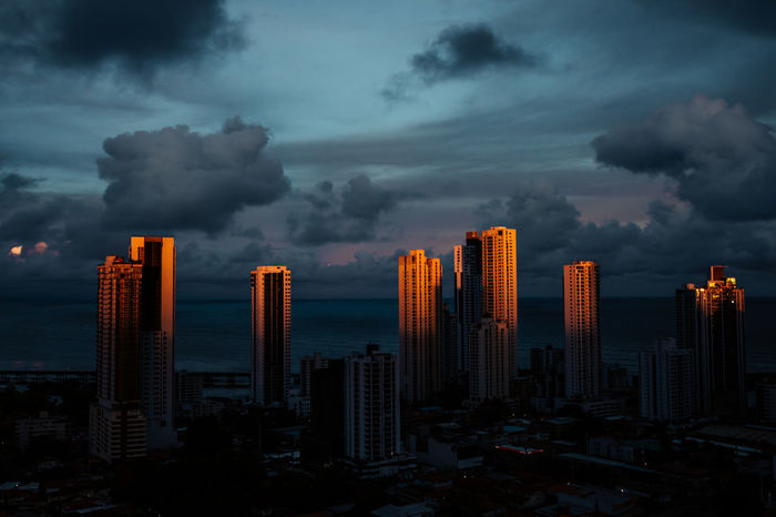 Buildings in city against sky at dusk