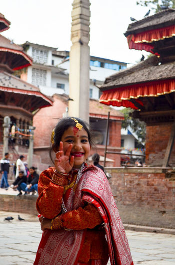 Portrait of girl in traditional clothing standing at temple