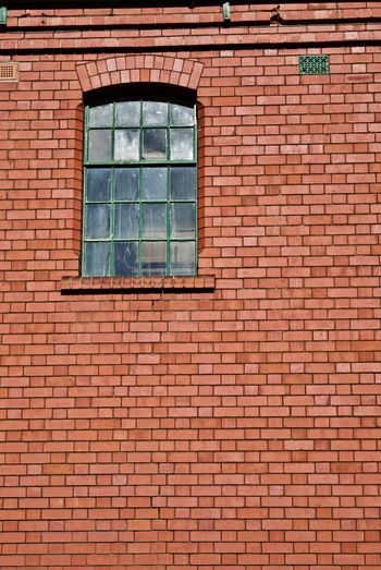Low angle view of window on brick wall