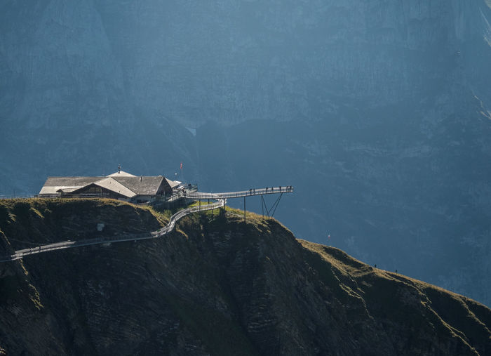 Scenic view of sea by mountain against sky