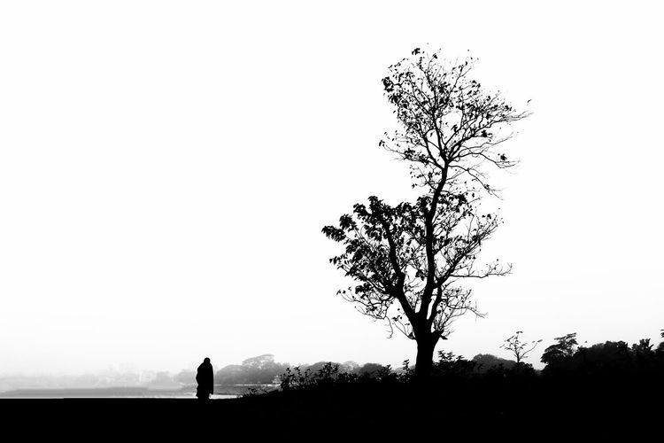 Silhouette man standing on field against clear sky