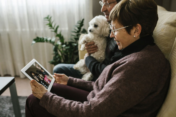 Grandparents on video call with family through tablet at home