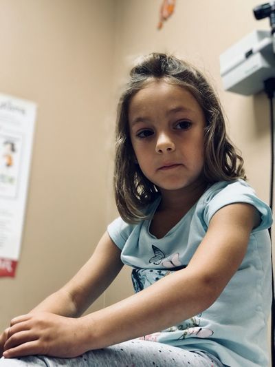 Portrait of cute girl sitting at clinic