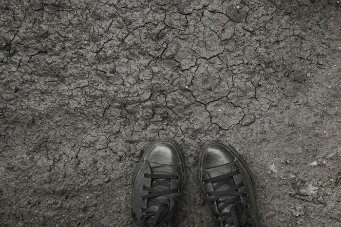 High angle view of shoes on cracked field