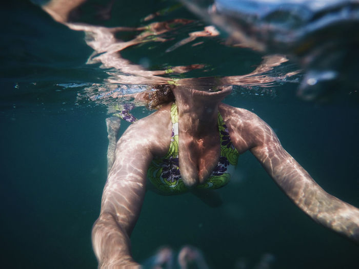 Low section of woman swimming in sea