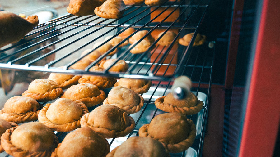 Close-up of baked pastry items on rack at bakery