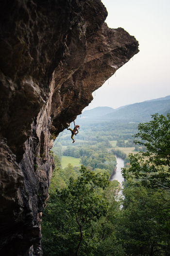 Man climbing overhanging sport climbing route in new hampshire