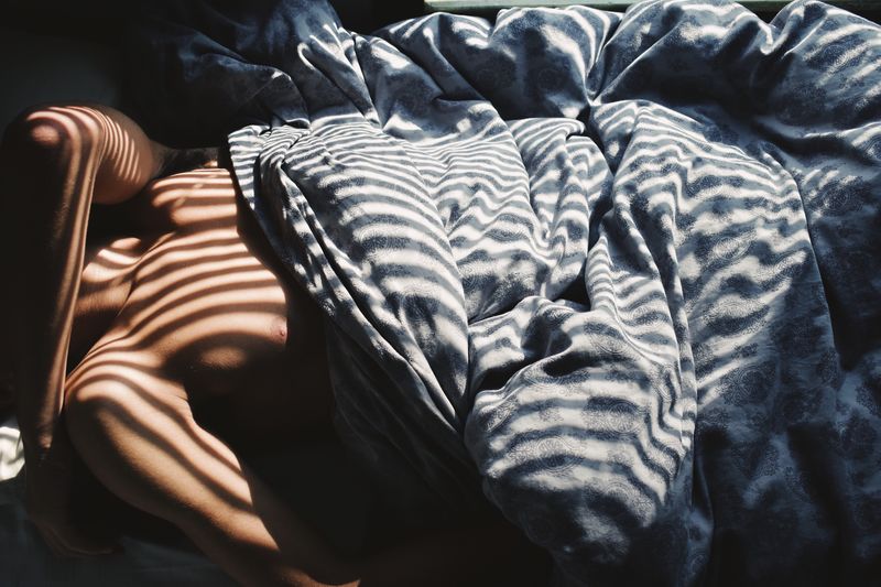 High angle view of shirtless man sleeping on bed