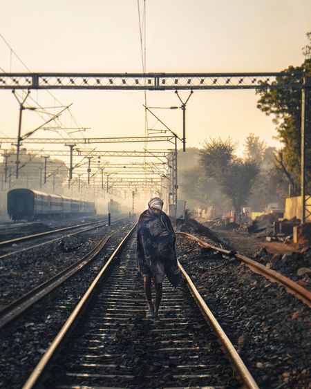 Rear view of man on railroad tracks