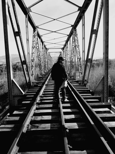 Rear view of man standing on bridge