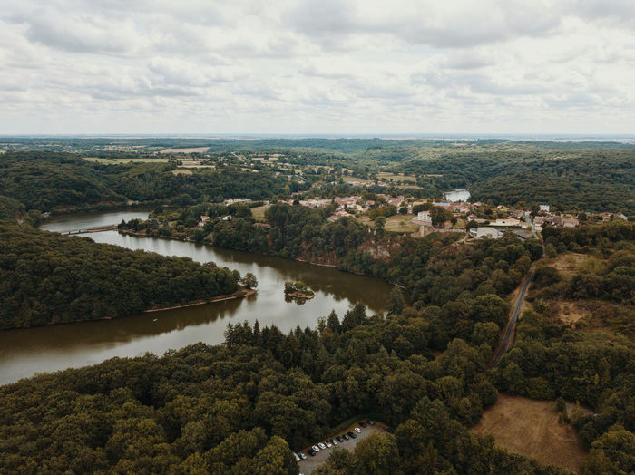 High angle view of typical french village against sky lost in forest in proximity of a river