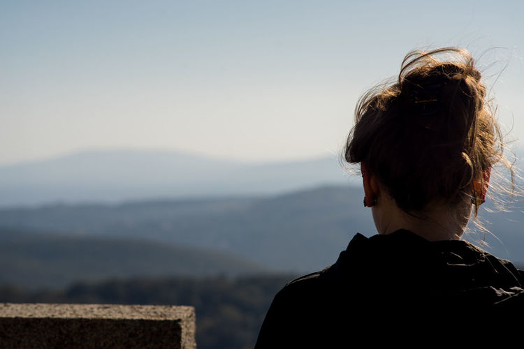 Rear view of woman looking at mountain against sky