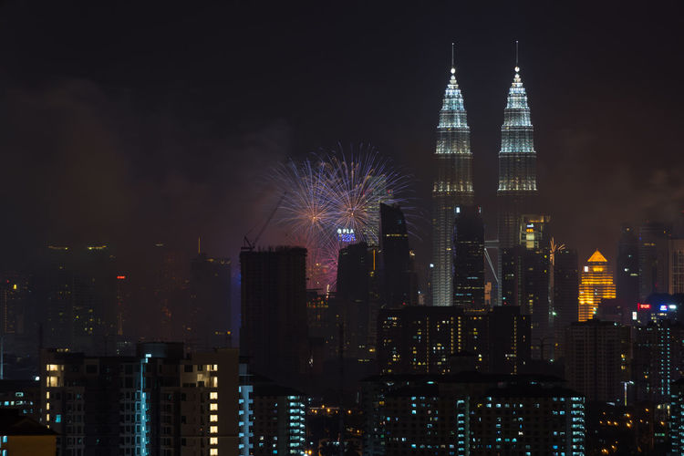 Illuminated petronas towers and fireworks at night