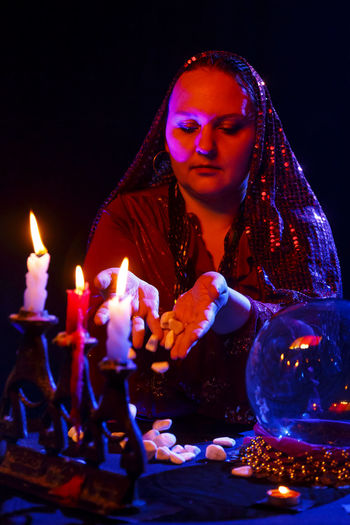 Portrait of young woman holding lit candle