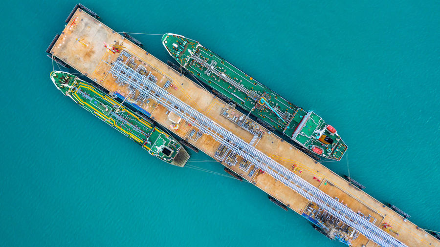 Aerial view of ship by pier over sea