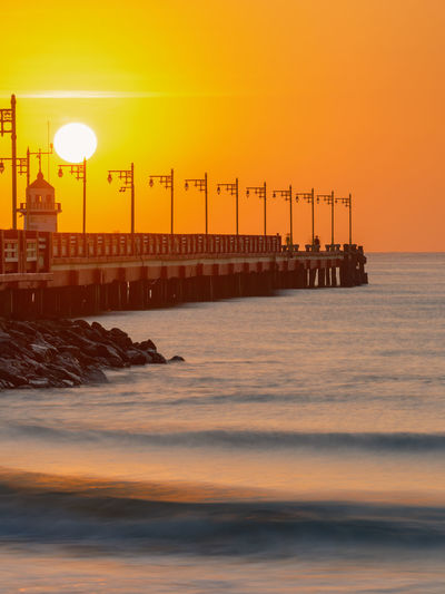 Beautiful sea and the bridge stretches out into the middle of the water with rows of lampposts