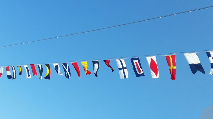 Low angle view of flags against clear sky