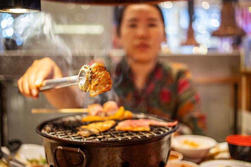 Woman preparing food on barbecue grill