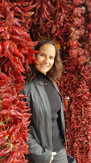 Portrait of mid adult woman standing by paprika at market stall