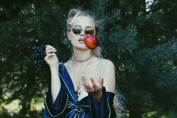 Woman throwing apple against trees