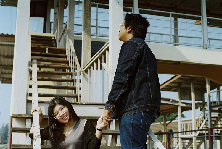 Full length of a young woman standing against building