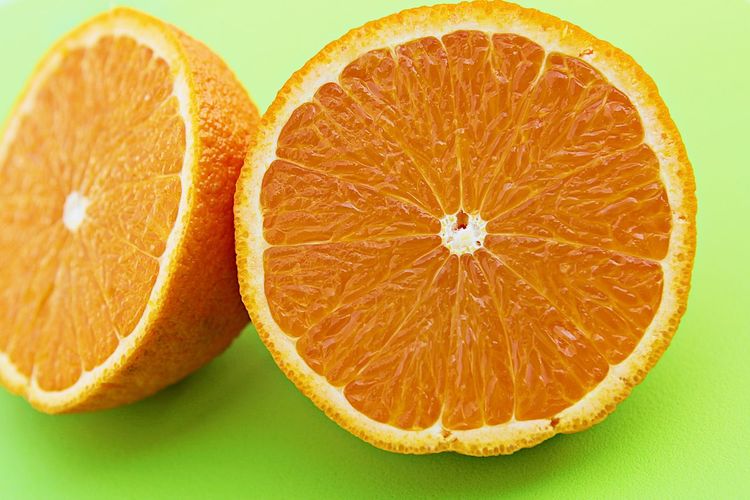 Close-up of lemon slice against orange background