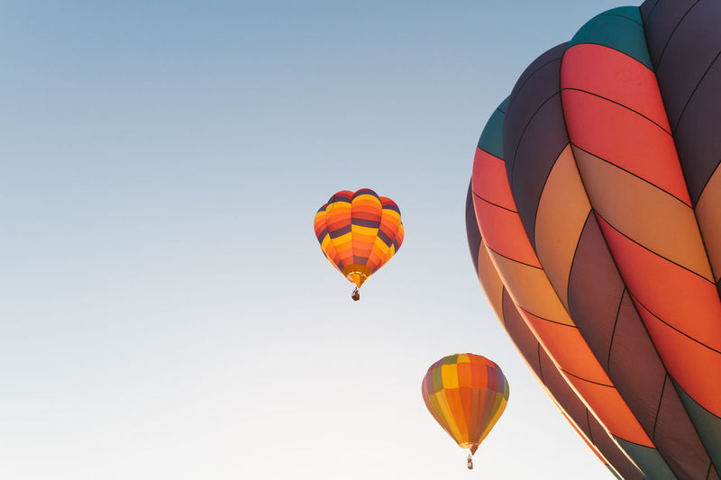 Low angle view of colorful hot air balloons against clear sky