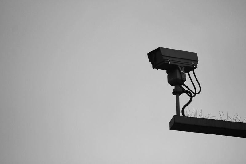Low angle view of surveillance camera against sky
