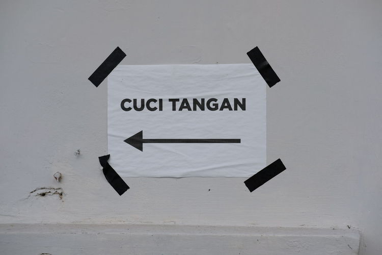 Close-up of arrow sign on wall