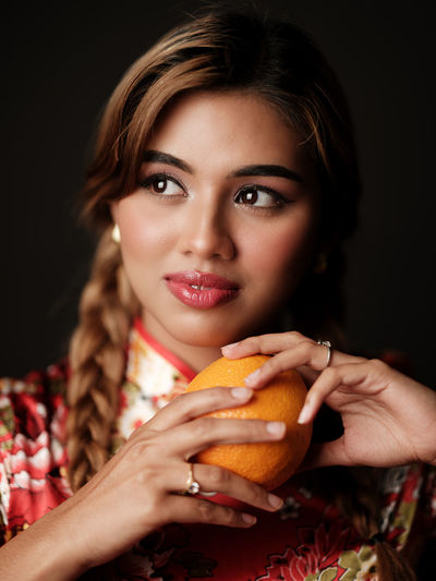Portrait of young woman holding pumpkin