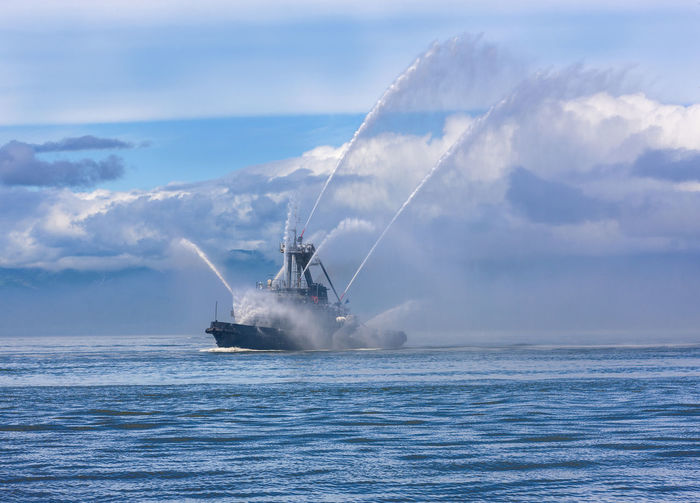 Fire hose boat spraying water on kamchatka on paciic ocean