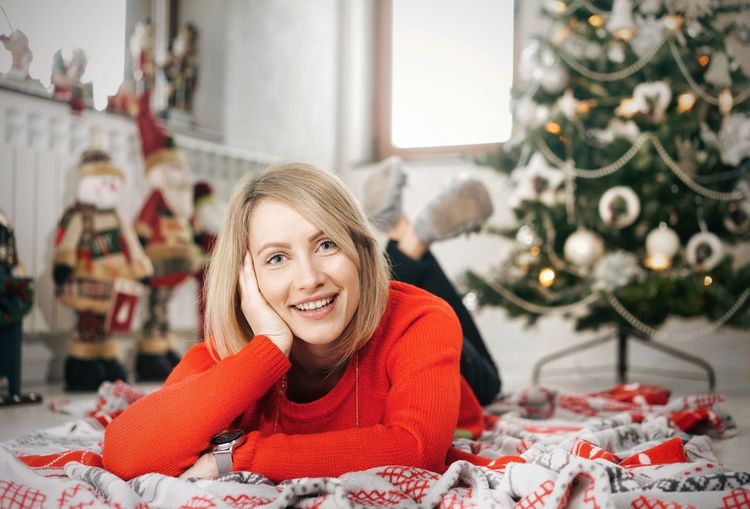 Portrait of smiling young woman lying on carpet
