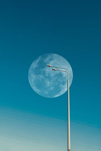 Low angle view of street light against blue sky