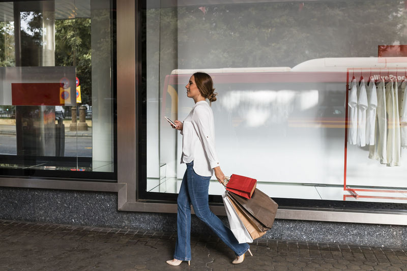 Woman with umbrella walking on glass window