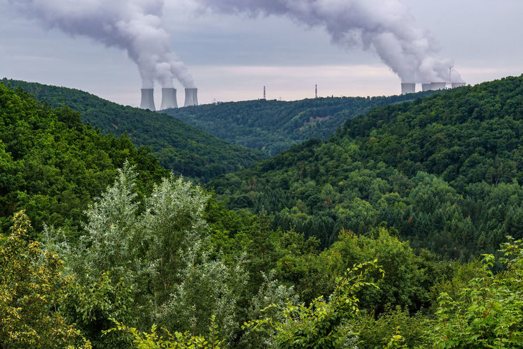 Valleys and on the horizon are the cooling towers of a nuclear power plant dukovany. czech republic.
