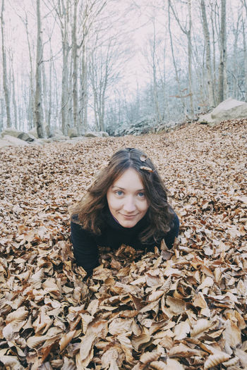 Portrait of smiling young woman in forest during autumn