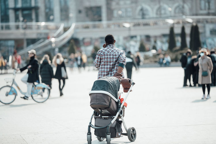 Rear view of people walking on street in city